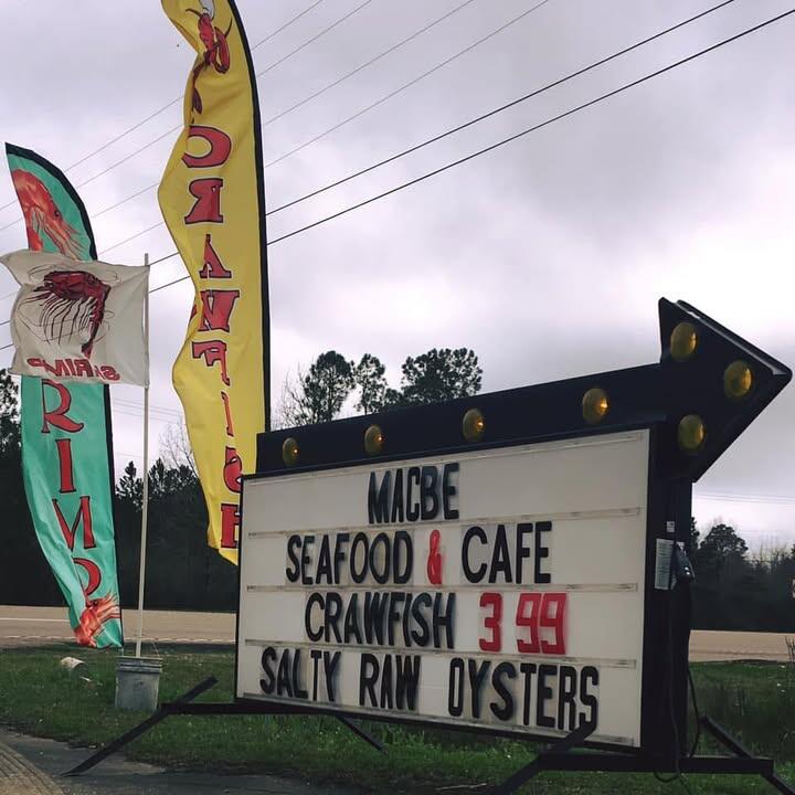 The MacBe Seafood & Cafe roadside sign on Highway 603, with shrimp flags.